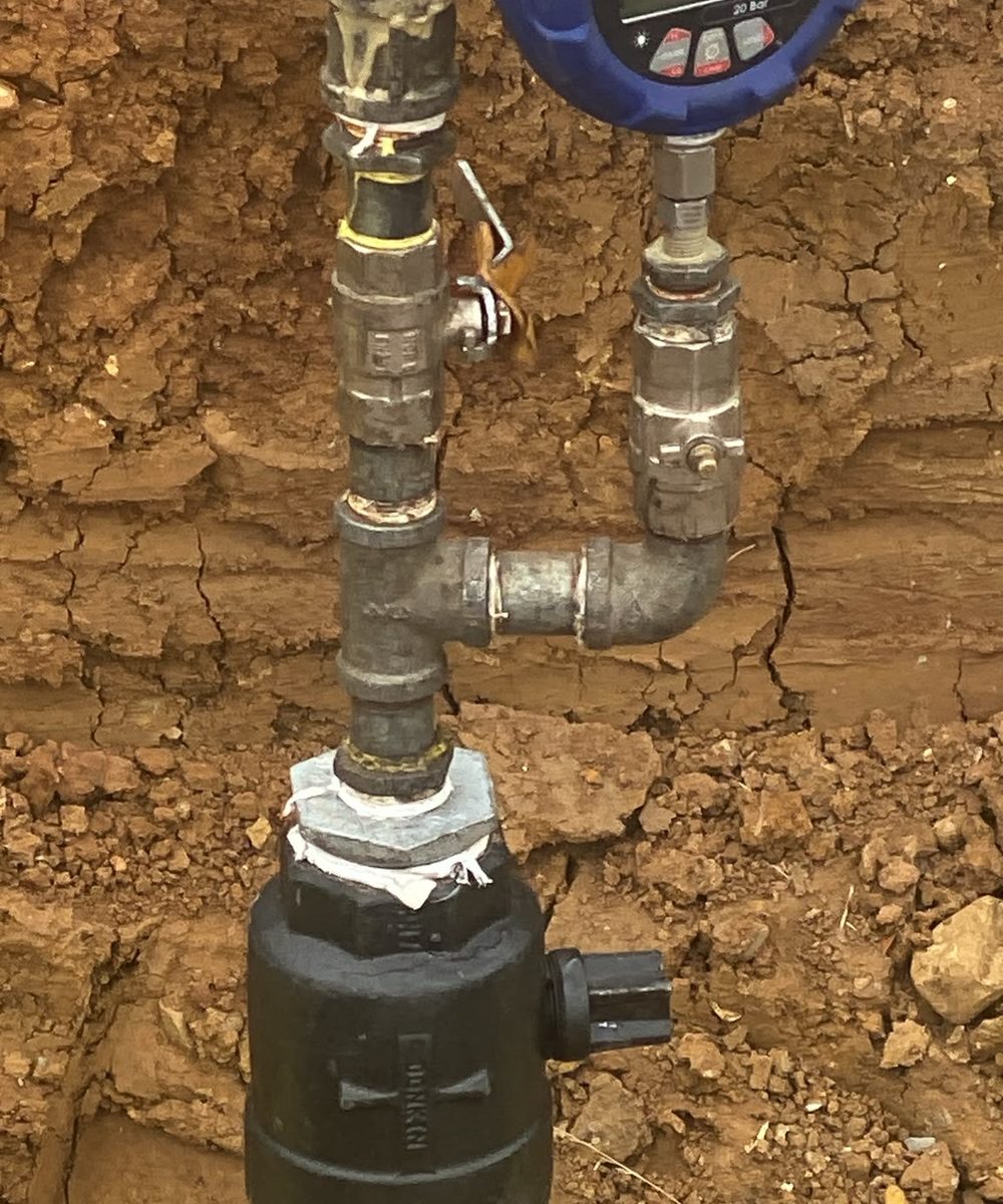 Digital pressure gauge on a test assembly fitted to a new PE main